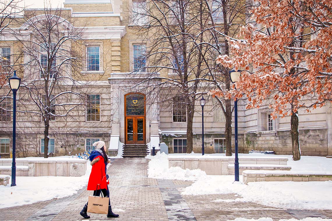 An image of a person walking in front of the Sandford Fleming Building.