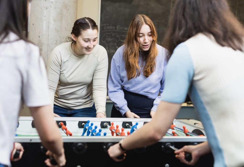 Students in the Common Room playing foosball